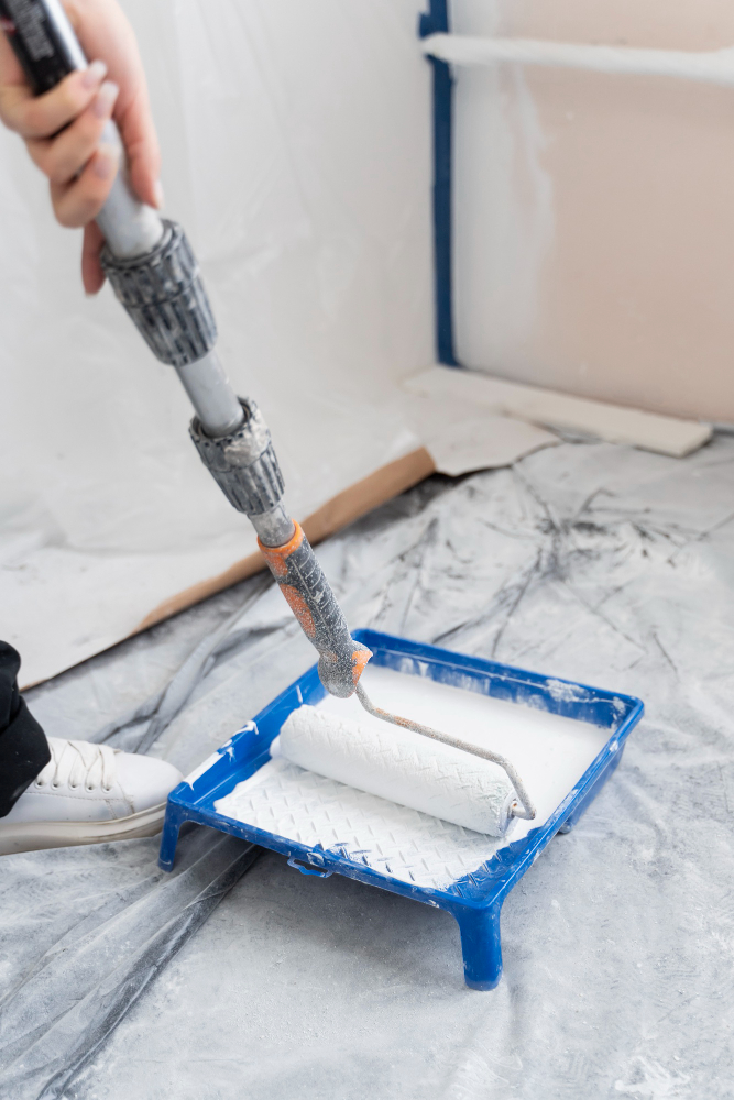 nettoyage industriel et collaborateur en train de passer le rouleau de peinture dans le seau