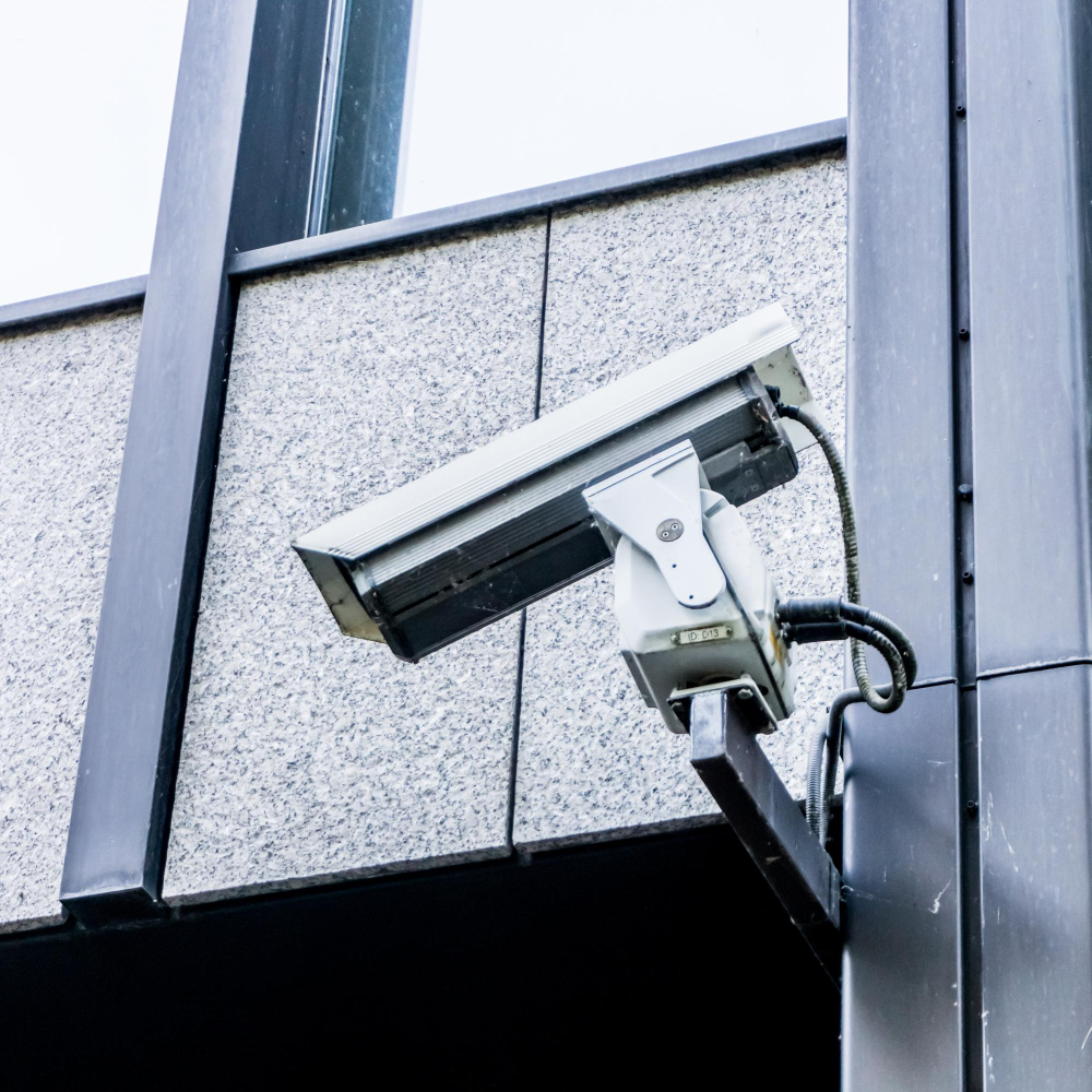 nettoyage industriel et caméra de surveillance posée sur le mur d'un immeuble de bureau
